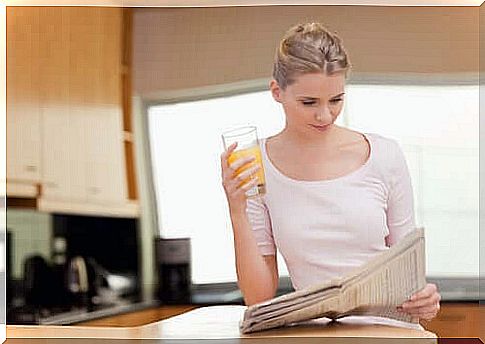 Woman with newspaper and orange juice