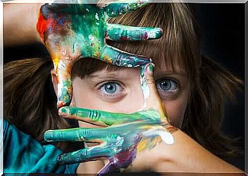 Little girl with paint-stained hands