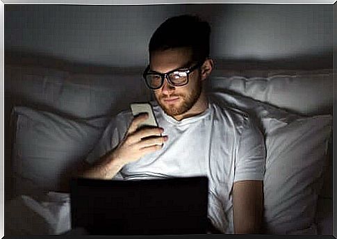 Man using cellphone in bed