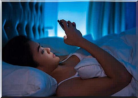 Woman using cellphone in bed