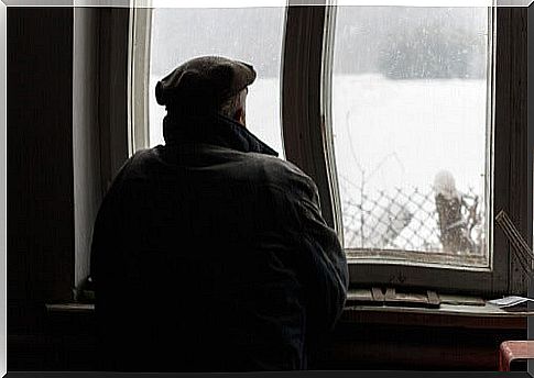 Senior watching the snow from the window