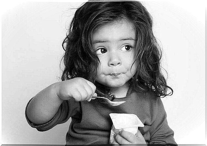 Little girl eating a yogurt