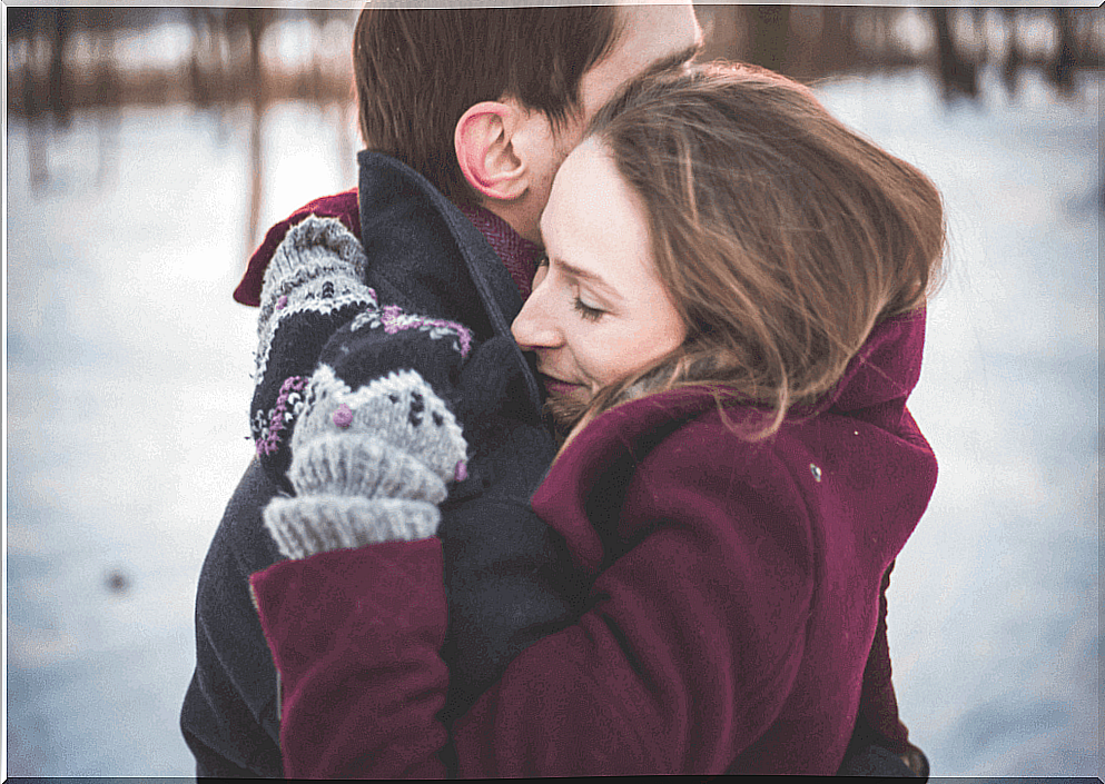 Couple hugs each other in winter