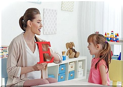 Mom shows a letter to her little girl who is learning to speak